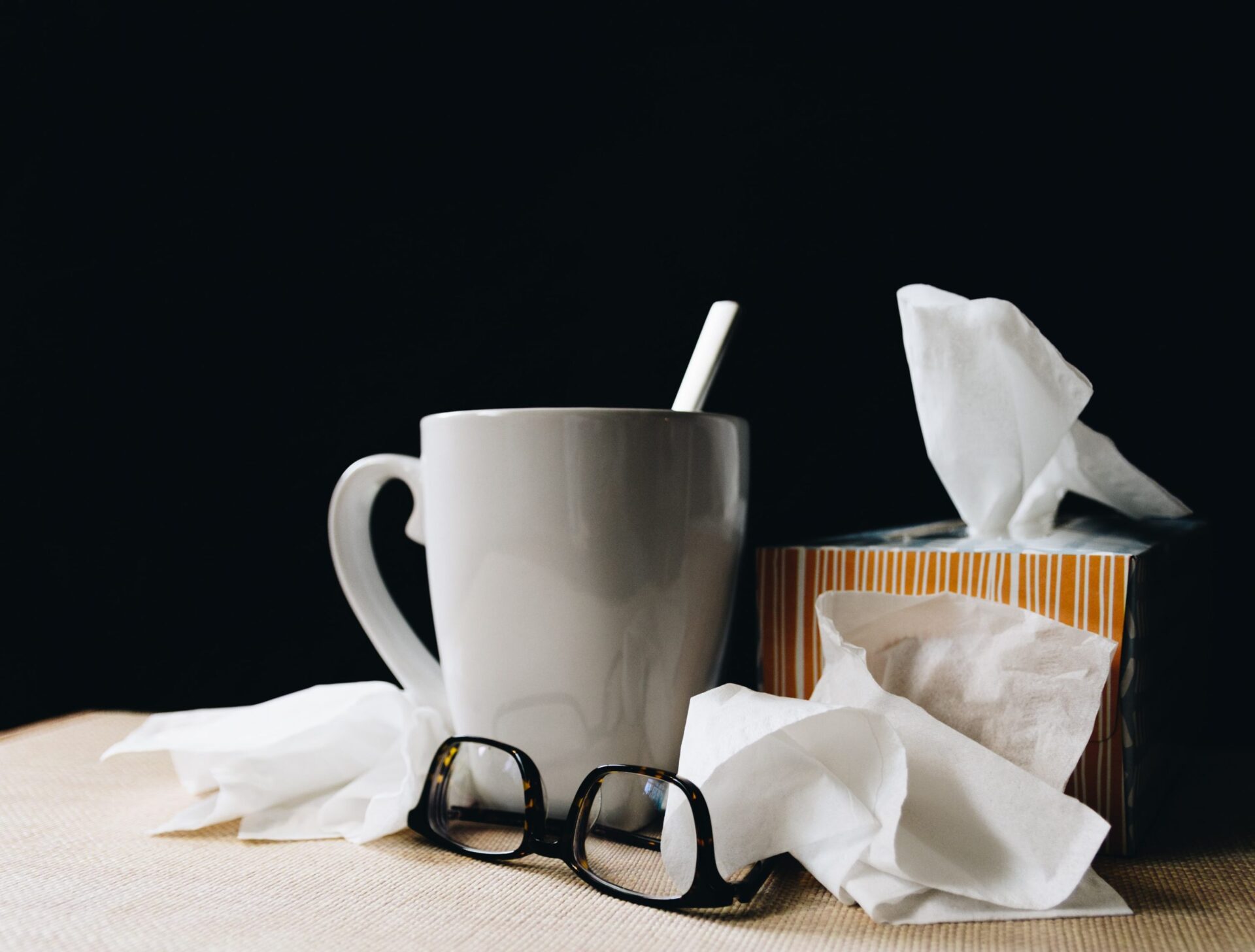 White mug, eyeglasses, and tissue box