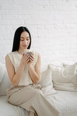 Woman relaxing with mug on white sofa