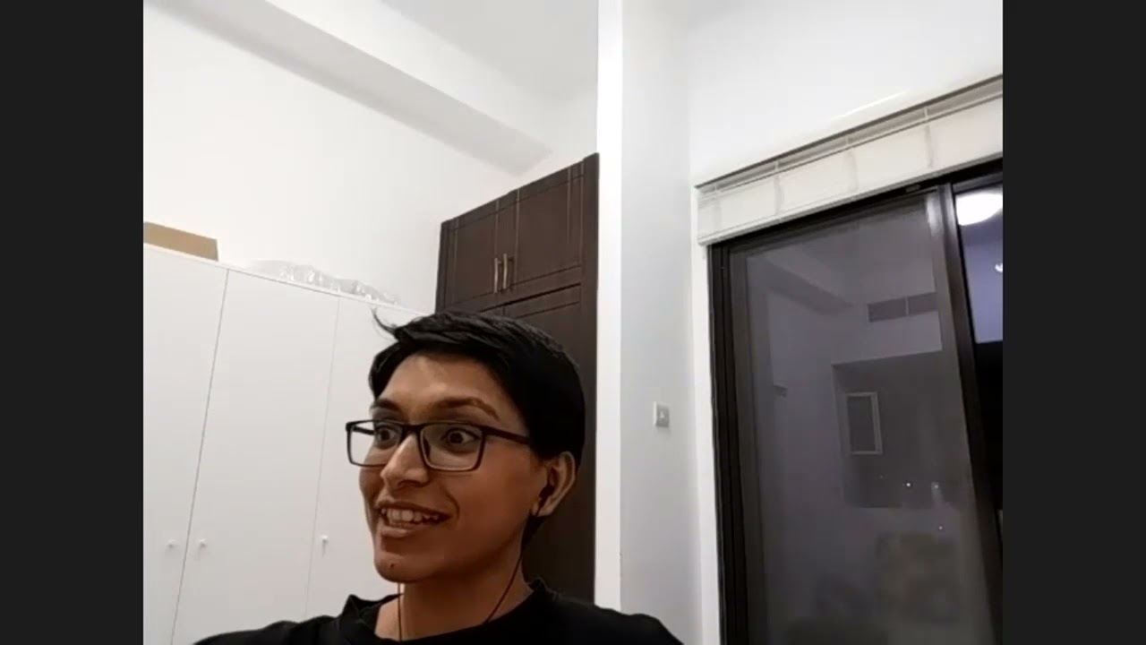 Smiling person with glasses wearing earphones