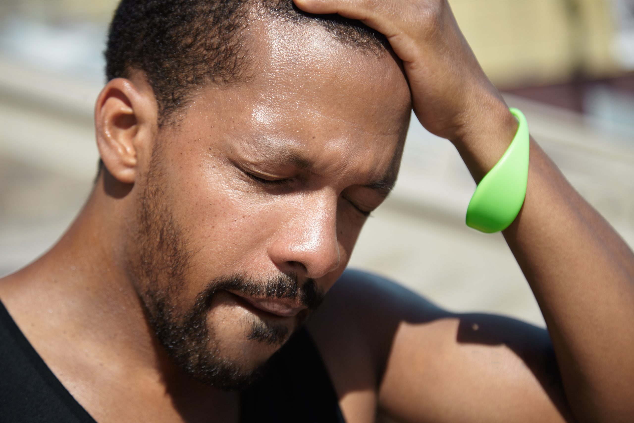 A man struggling to breathe, showing visible discomfort from intense heat.